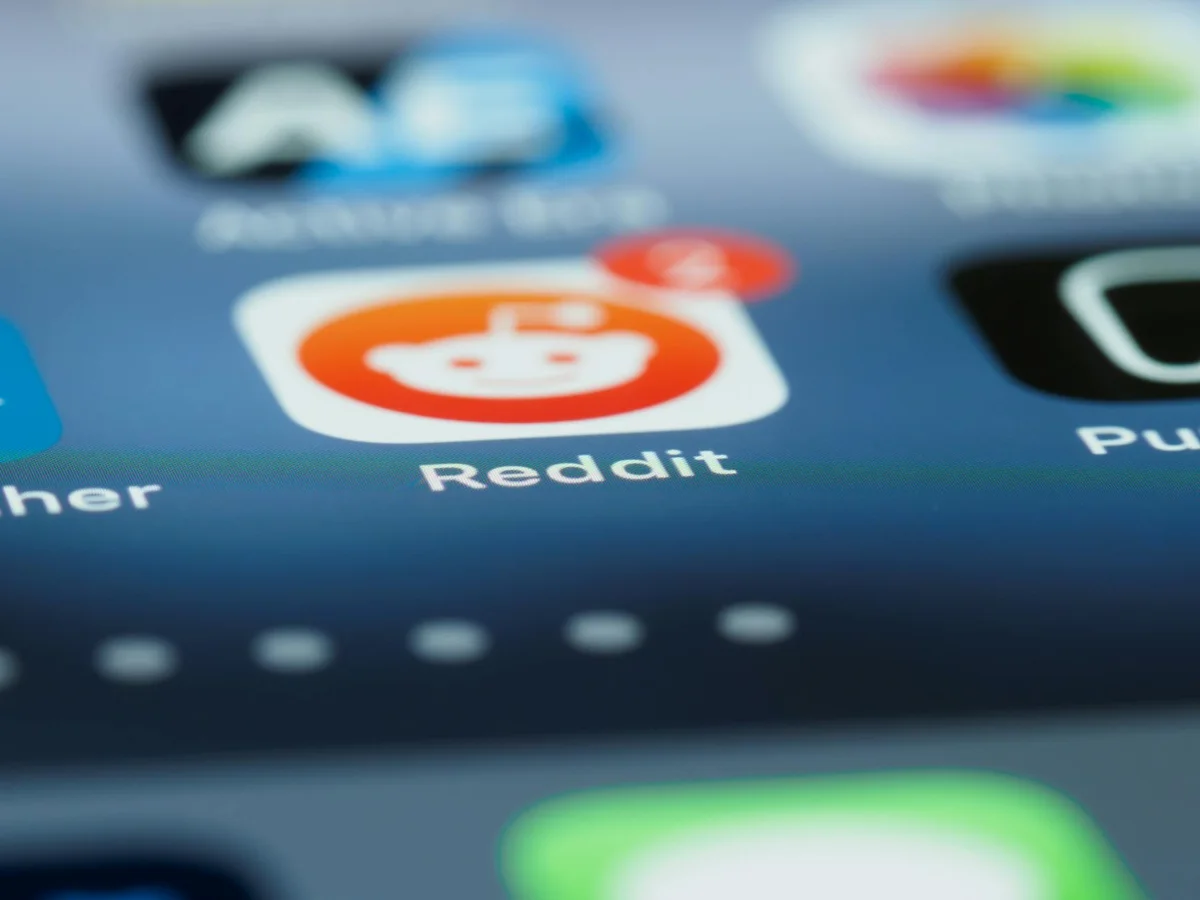Automatizar TikTok con sistemas: lo que el libro enseña sobr... — Detailed close-up of a smartphone screen showing the Reddit app with a notificat