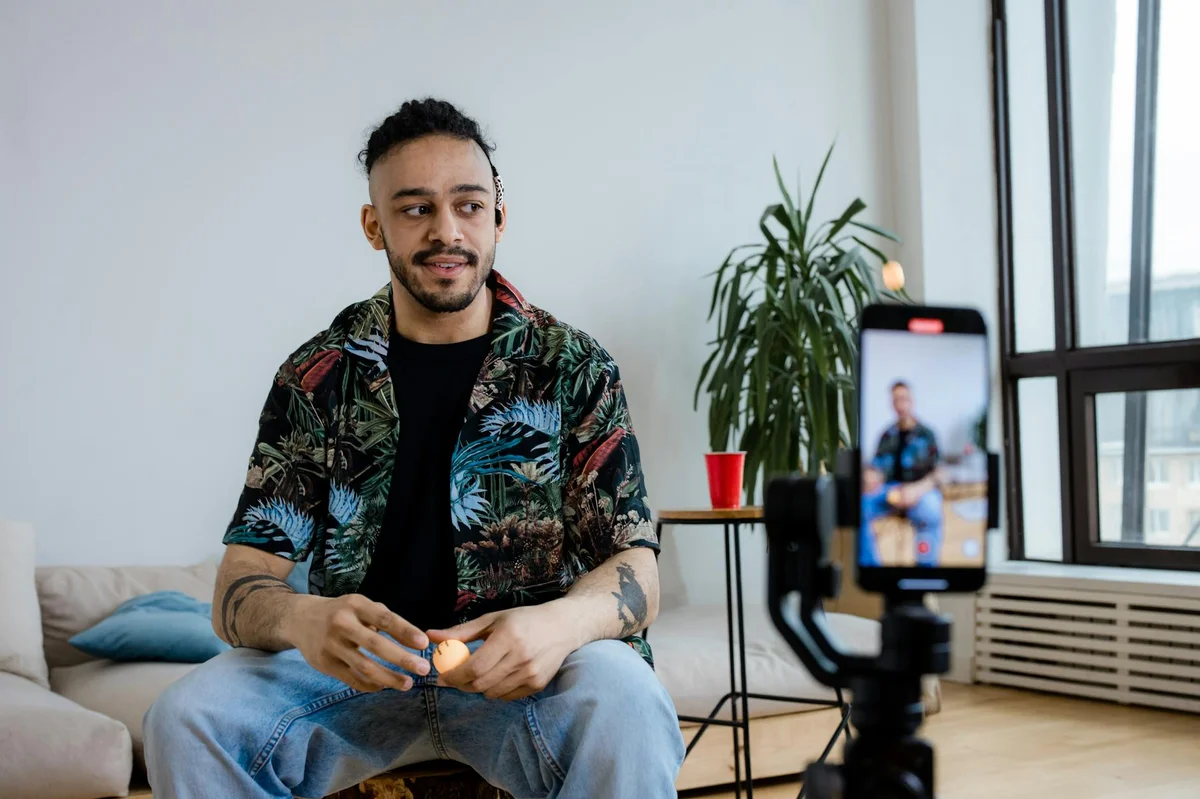 TikTok como negocio: las claves del libro para vender sin pe... — A young man recording video content indoors with a smartphone and tripod.