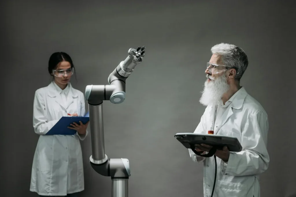 Usa la IA contra tus propias ideas: abogado del diablo, prem... — Two scientists working with a robotic arm in a lab setting, focusing on innovati