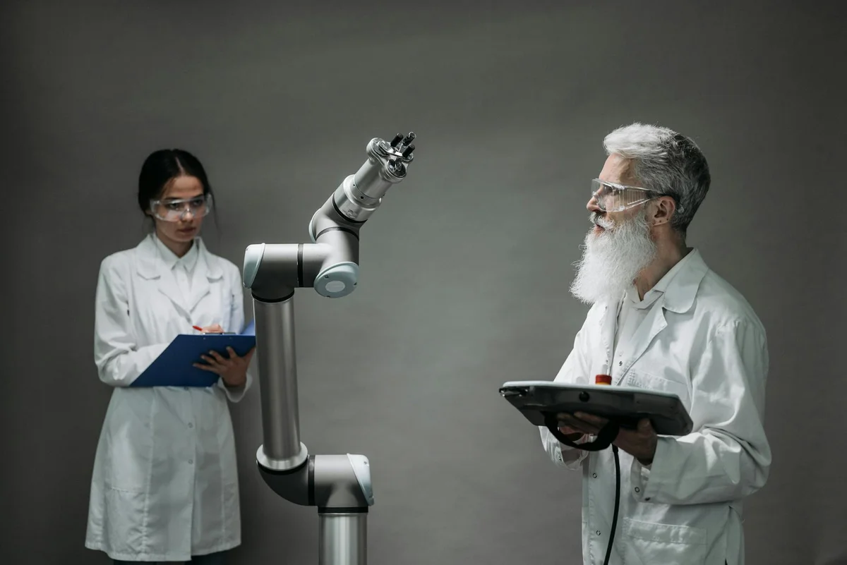 Usa la IA contra tus propias ideas: abogado del diablo, prem... — Two scientists working with a robotic arm in a lab setting, focusing on innovati