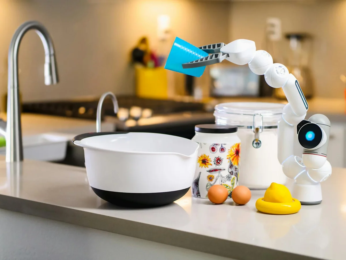 Trabajo Tranquilo: el libro que cambia como entiendes la pro... — A robotic arm assists with mixing ingredients in a modern kitchen, showcasing ad