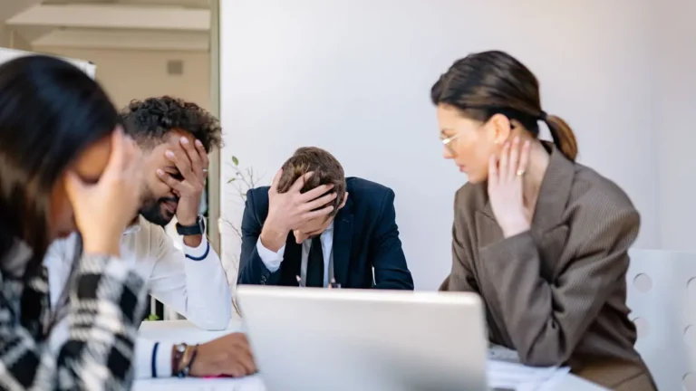 A group of stressed business professionals in an office setting, overwhelmed by work.