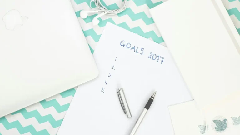 Photo of a workspace featuring a notepad labeled Goals 2017, pen, and laptop for planning.