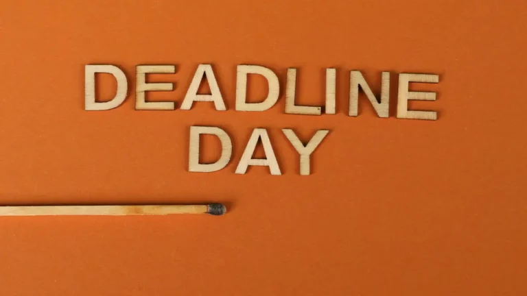 Conceptual image of a deadline with wooden letters and burnt matchstick on orange background.